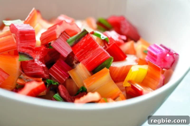 Finely sliced and chopped Swiss chard stems are collected in a small bowl, indicating they are also being prepared for inclusion in the recipe.