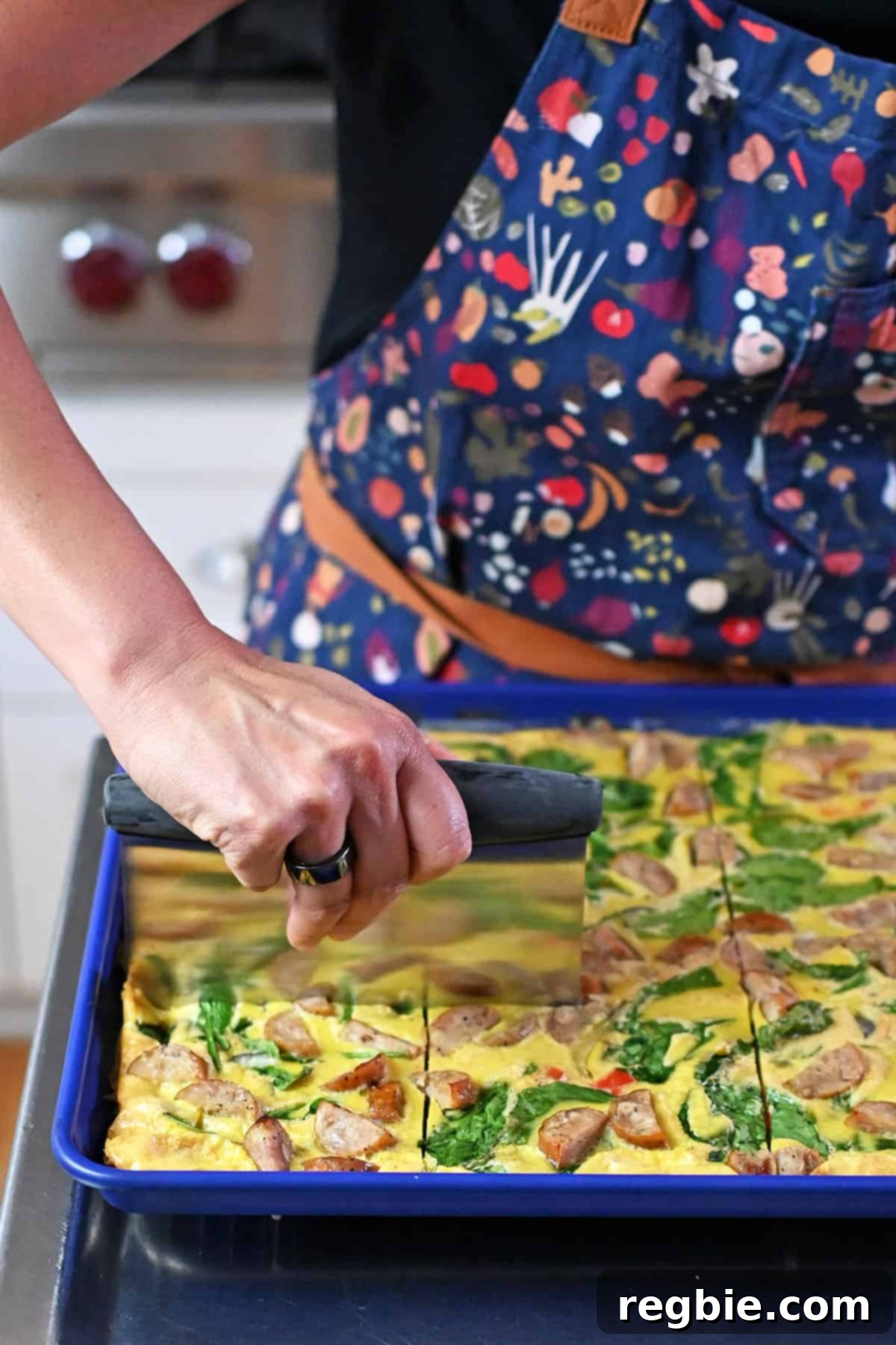 Slicing cooked sheet pan eggs with a metal dough scraper.