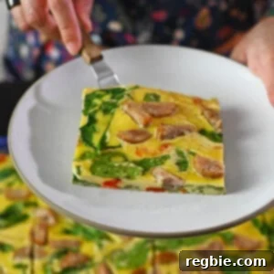 A square slice of sheet pan eggs on a small plate over a pan of sheet pan eggs.