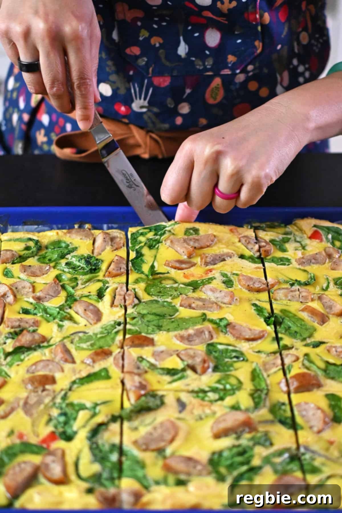 Using a small offset spatula to remove a slice of sheet pan eggs.