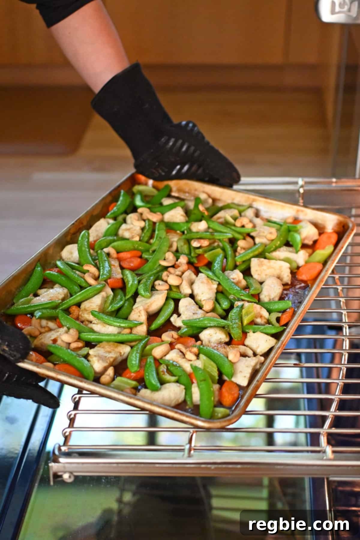 Sheet Pan Cashew Chicken: Paleo & Whole30 Perfection 16 A tray of Sheet Pan Cashew Chicken, glistening with sauce and perfectly cooked, is being triumphantly removed from the oven.