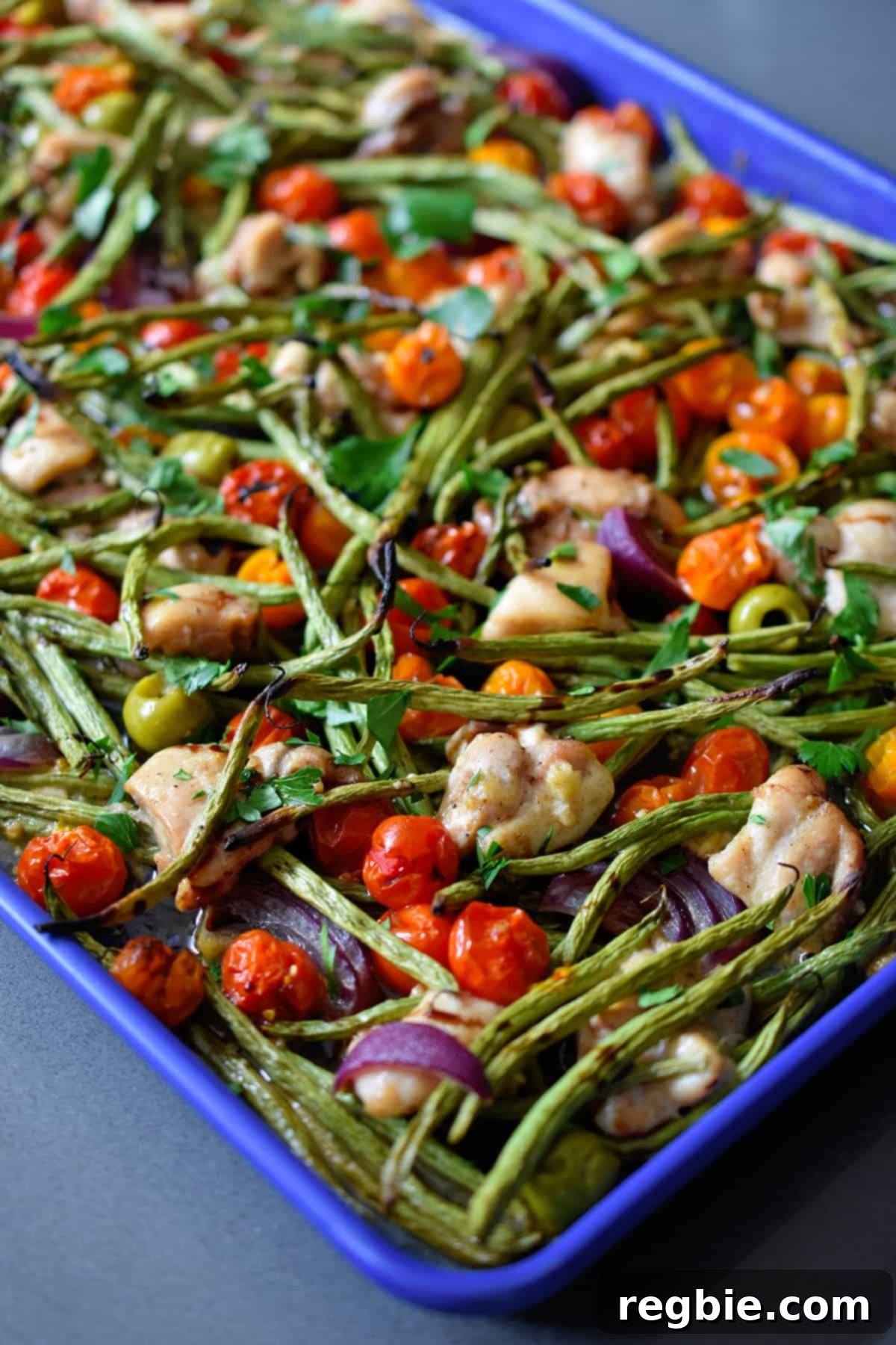 A side view of the paleo sheet pan Italian chicken immediately after being removed from the oven, showing perfectly roasted vegetables and cooked chicken.