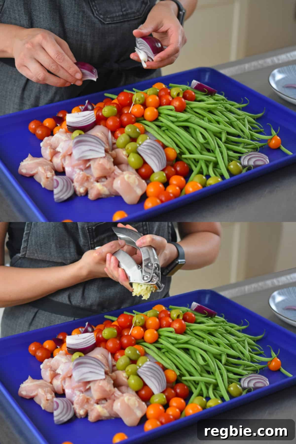 Two shots showing the addition of raw red onion wedges and minced garlic to a blue sheet pan already containing cubed raw chicken, green beans, and cherry tomatoes, illustrating the ingredient layering process.