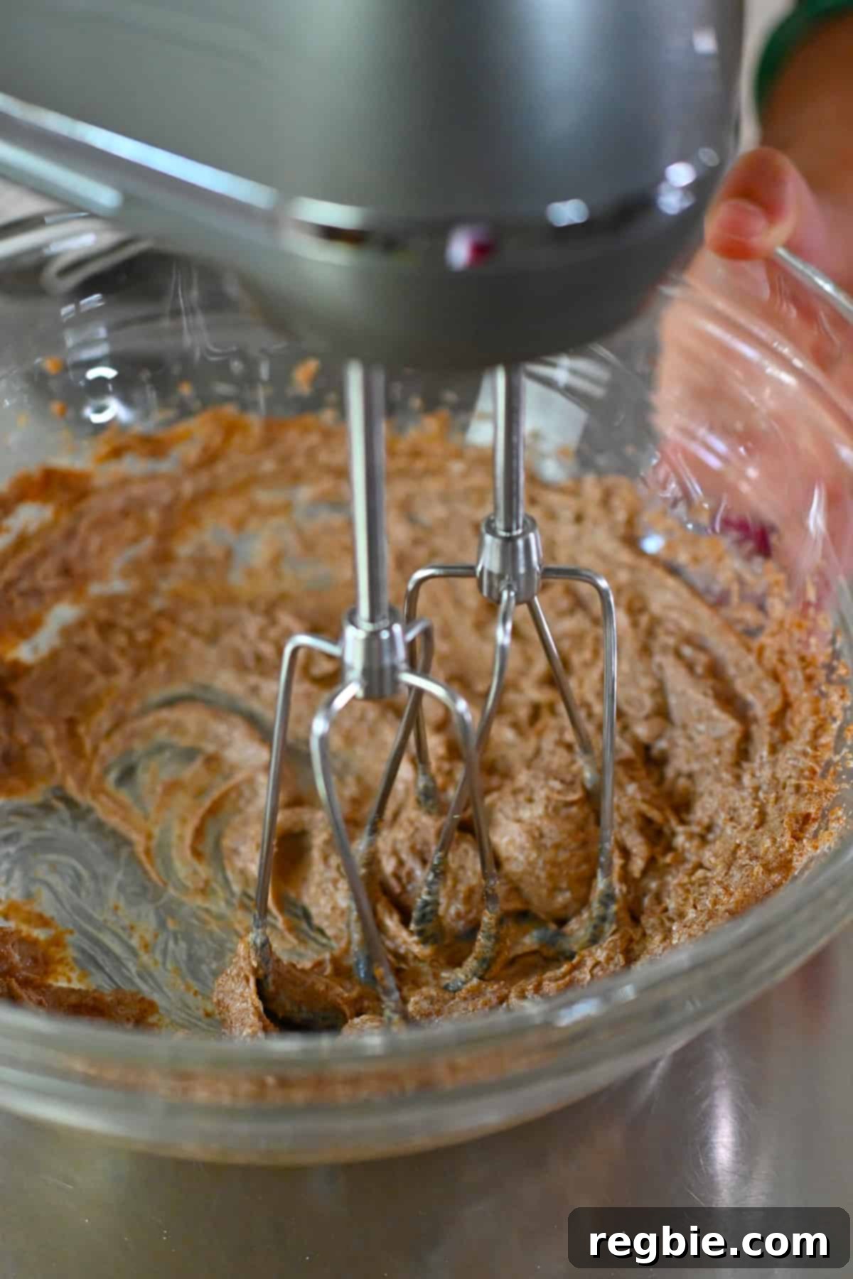 Paleo Pumpkin Bliss Cookies 10 An overhead shot of a hand mixer blending together coconut oil and coconut sugar to make pumpkin cookies.