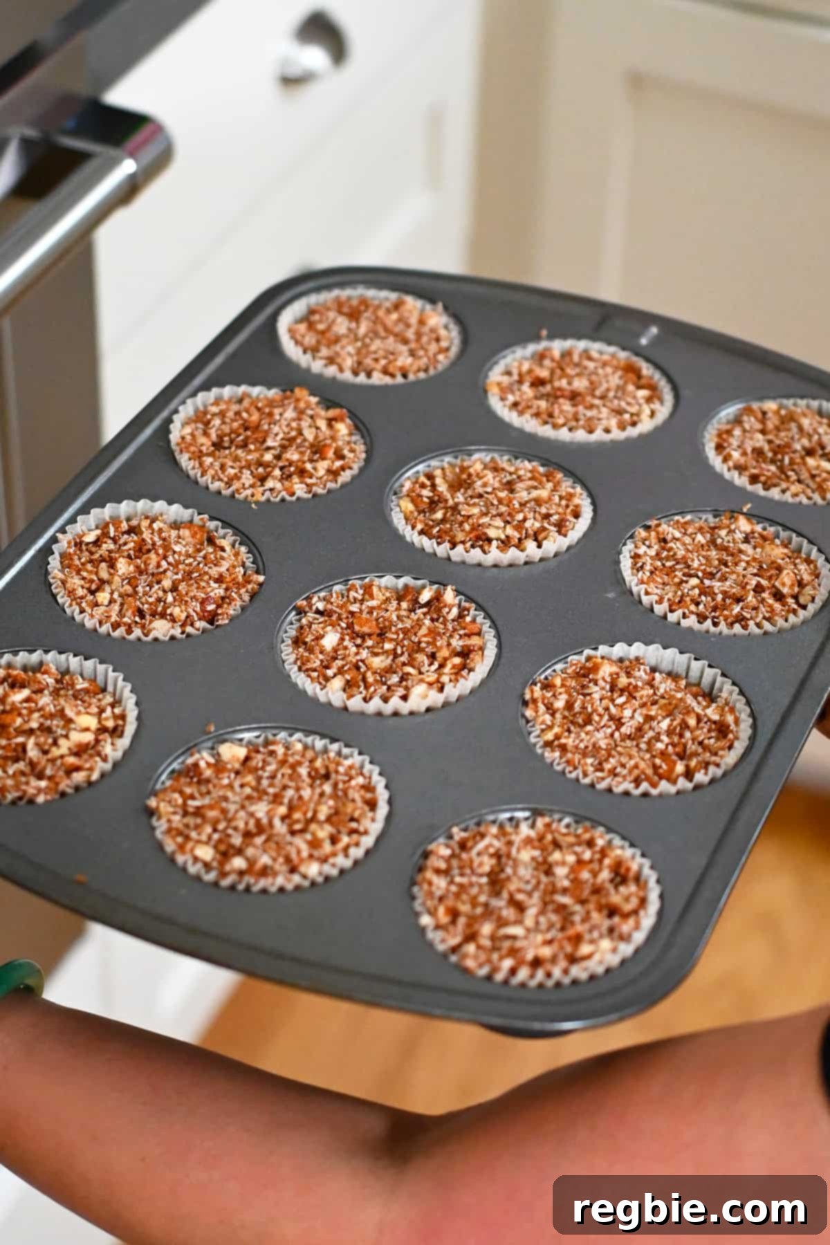 Placing a tray of paleo and gluten free apple muffins into the oven for baking.