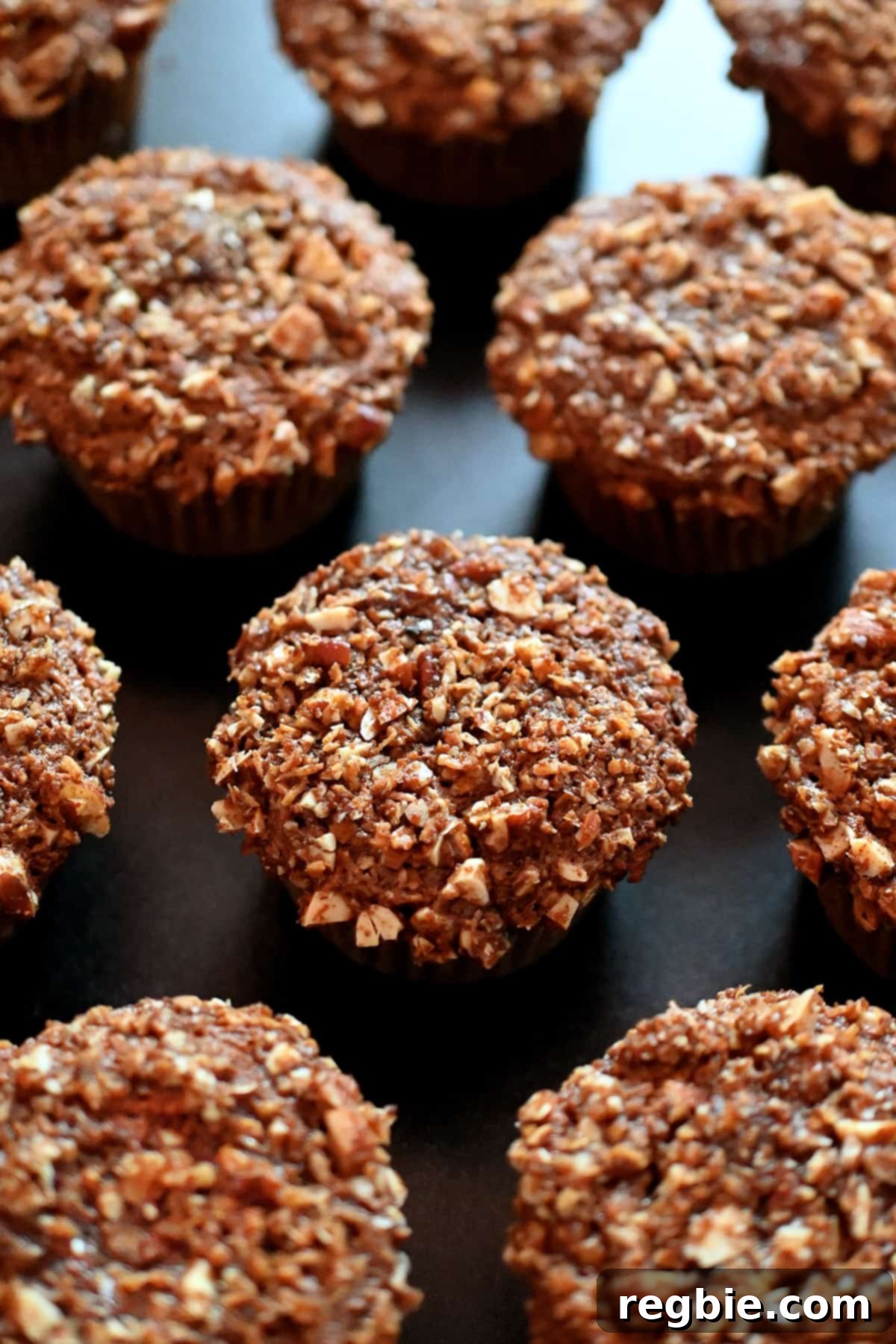 An overhead shot of paleo and gluten free apple muffins on a black background, ready for storage.