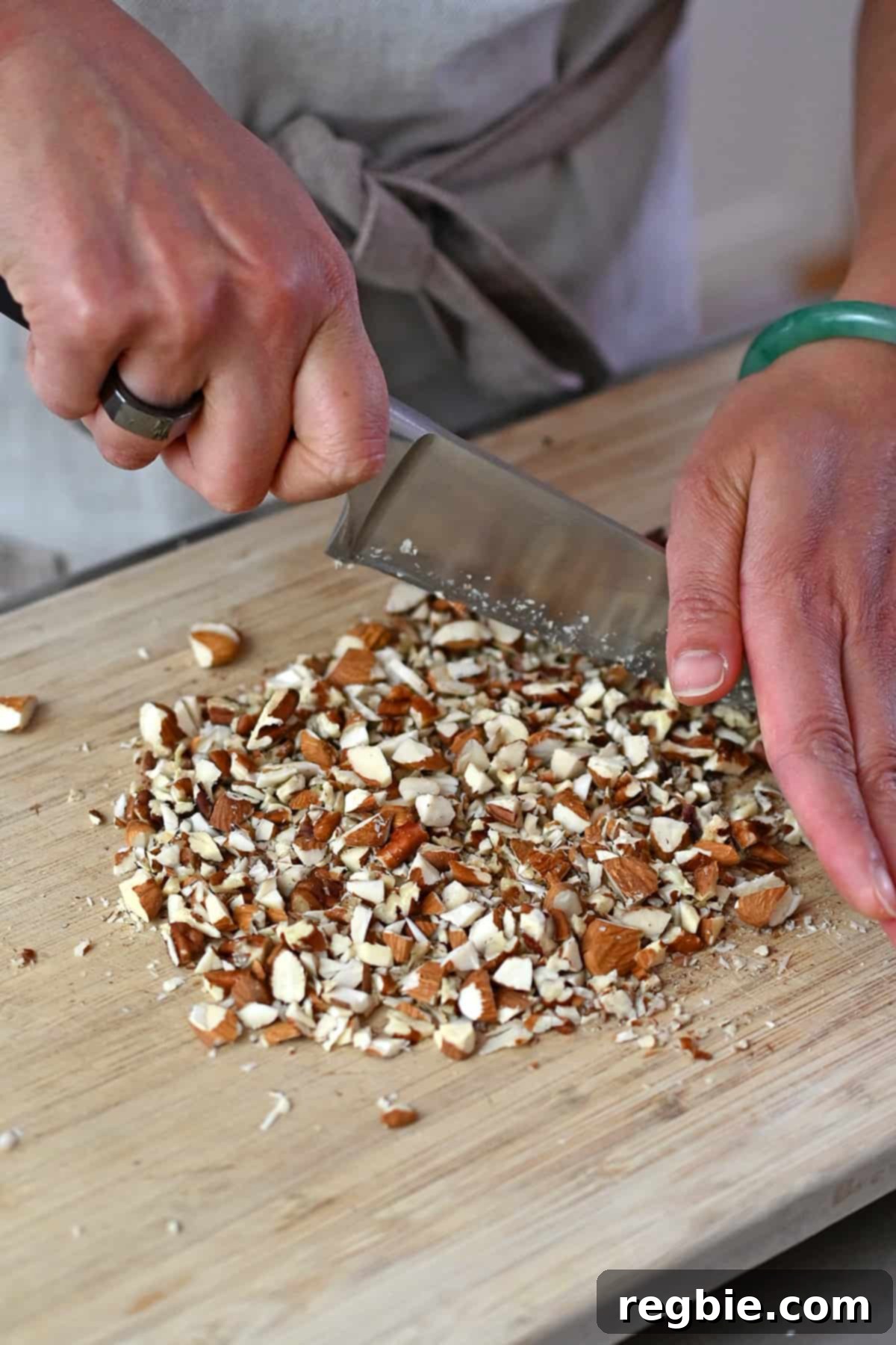 Chopping almonds and pecans by hand to make the topping for paleo apple muffins.