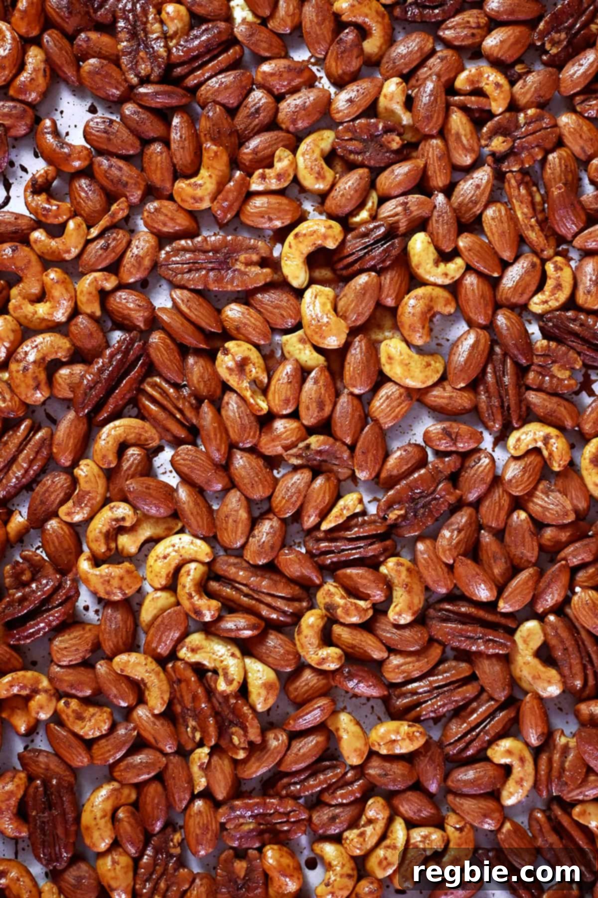 An inviting overhead shot of a rimmed baking sheet brimming with freshly roasted paleo spiced nuts, perfectly golden and ready to be devoured.