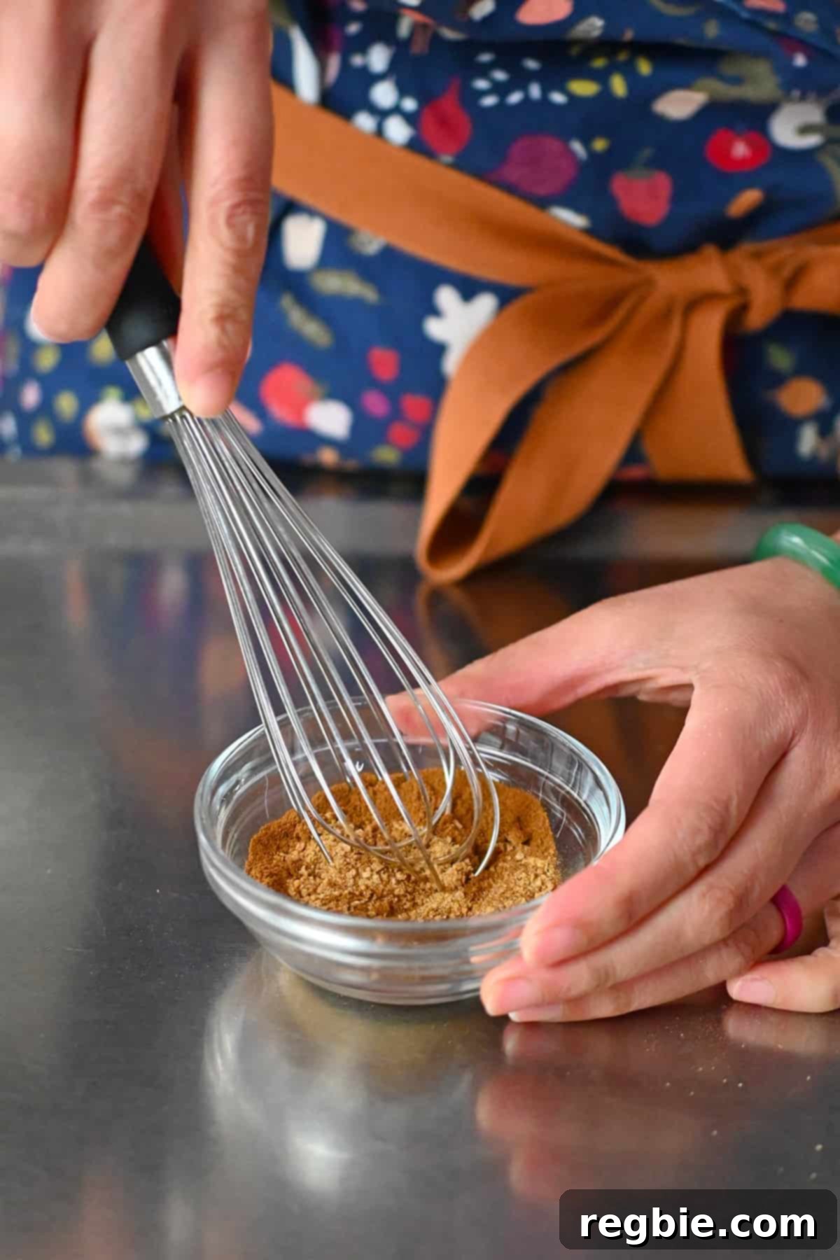 Using a whisk to blend the cinnamon sugar coating ingredients for snickerdoodles in a small bowl.