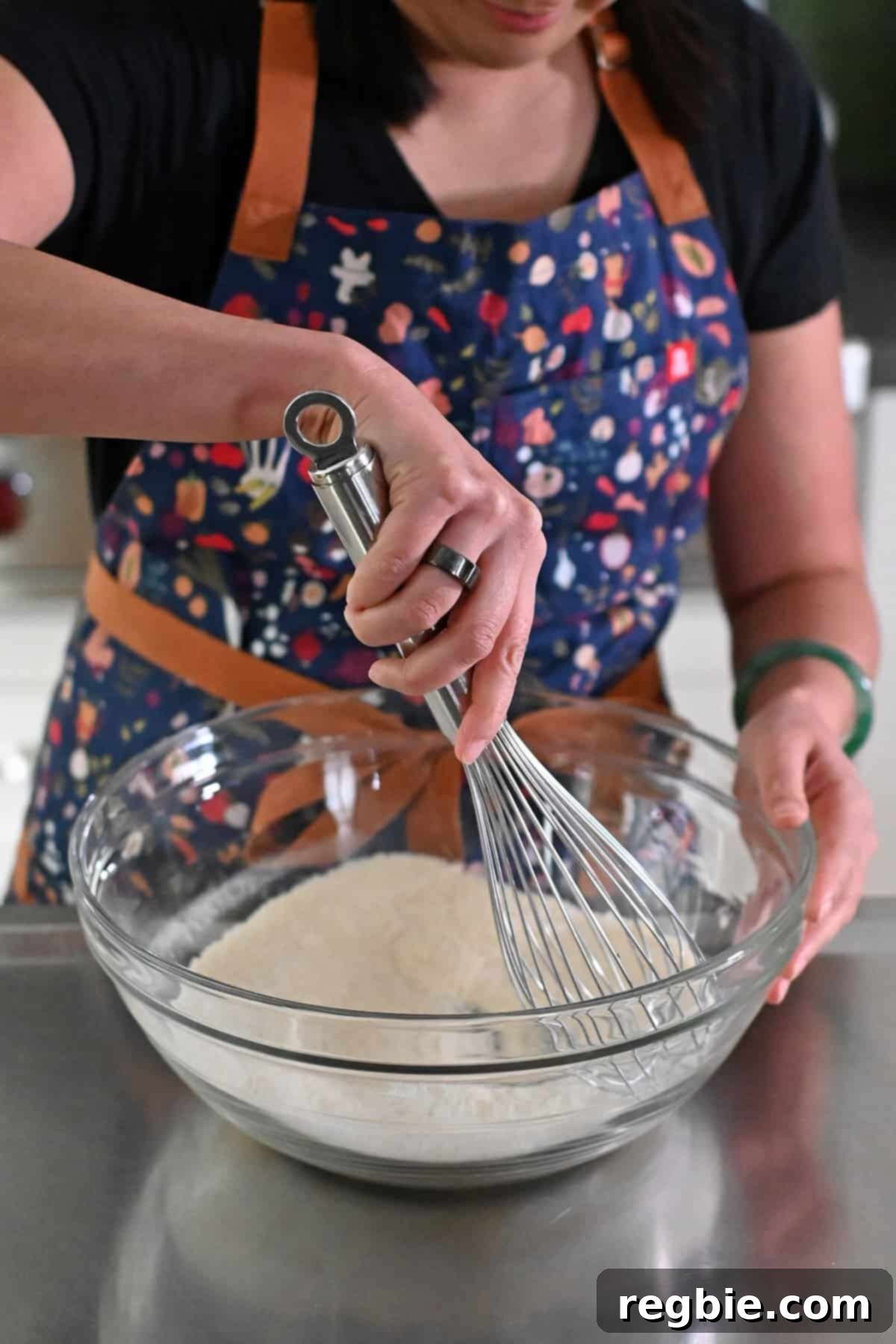 Whisking the dry ingredients for paleo and gluten-free snickerdoodles in a large glass mixing bowl until well combined.