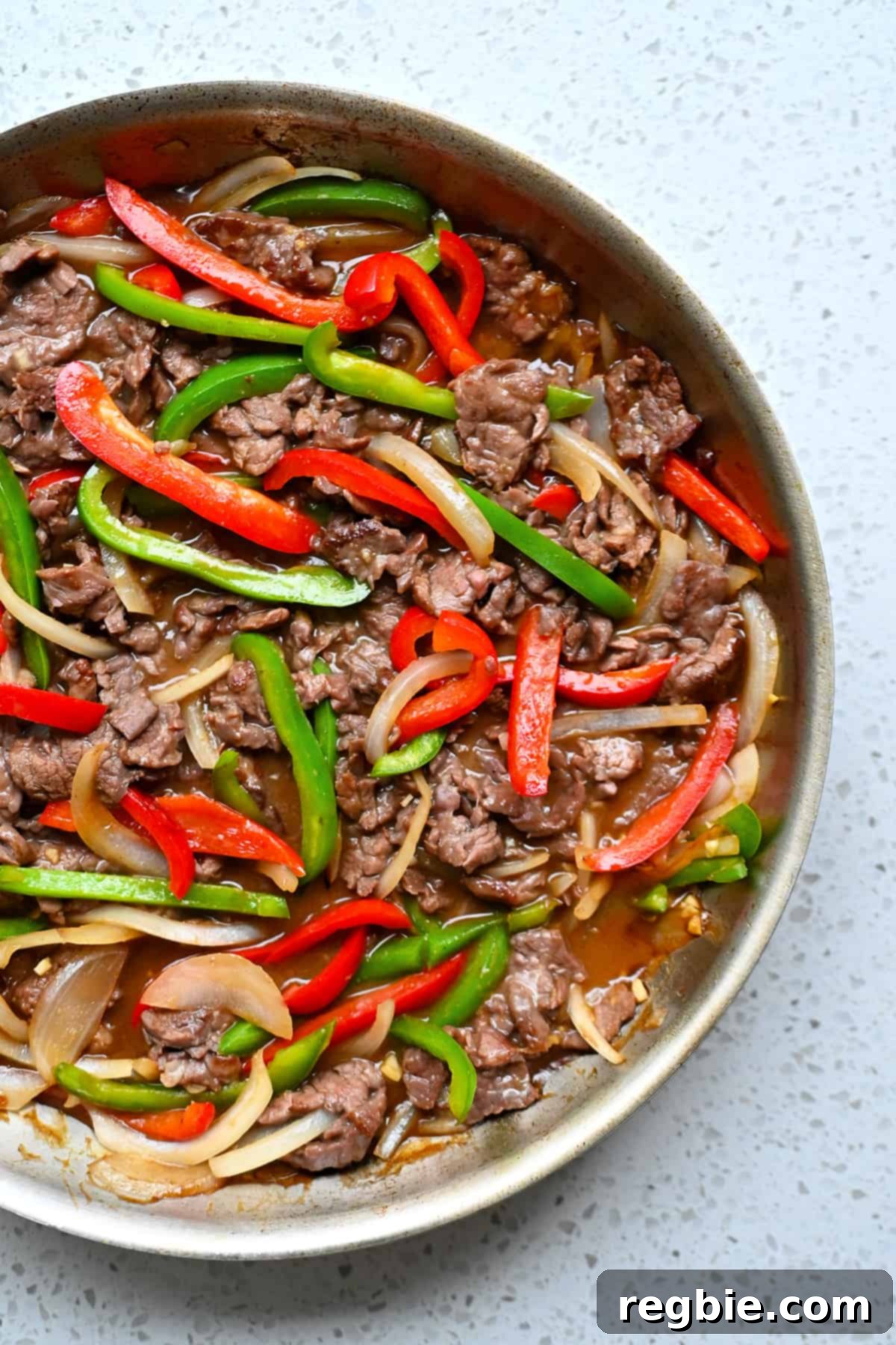 An overhead shot of 3/4 of a skillet filled with paleo and gluten free pepper steak.