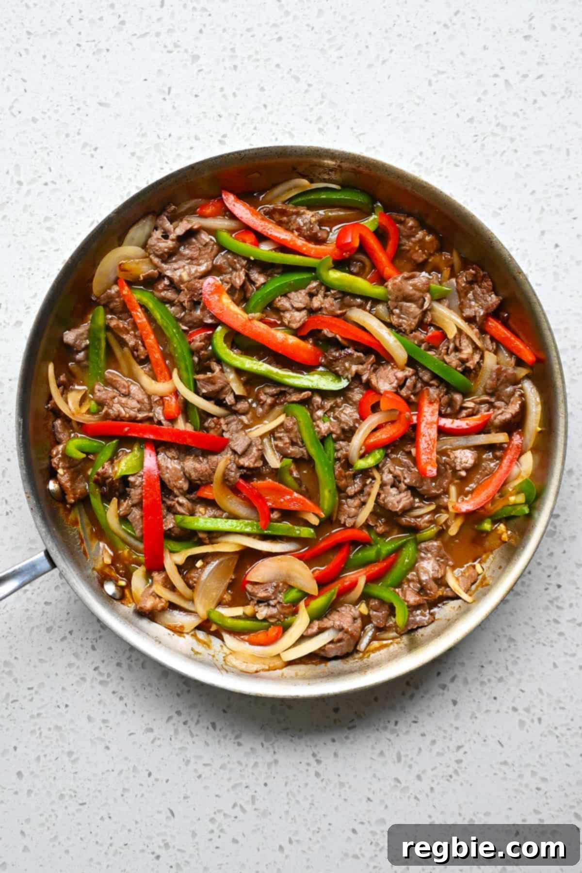 An overhead shot of a stainless steel skillet filled with paleo and gluten free pepper steak.