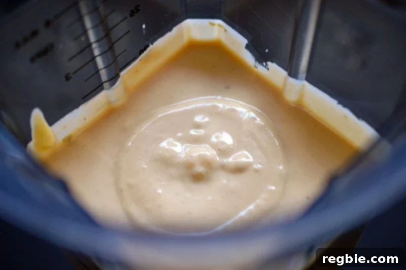 An overhead shot of an open blender container filled with creamy and keto Tonnato Sauce, highlighting its perfect, ready-to-serve consistency.