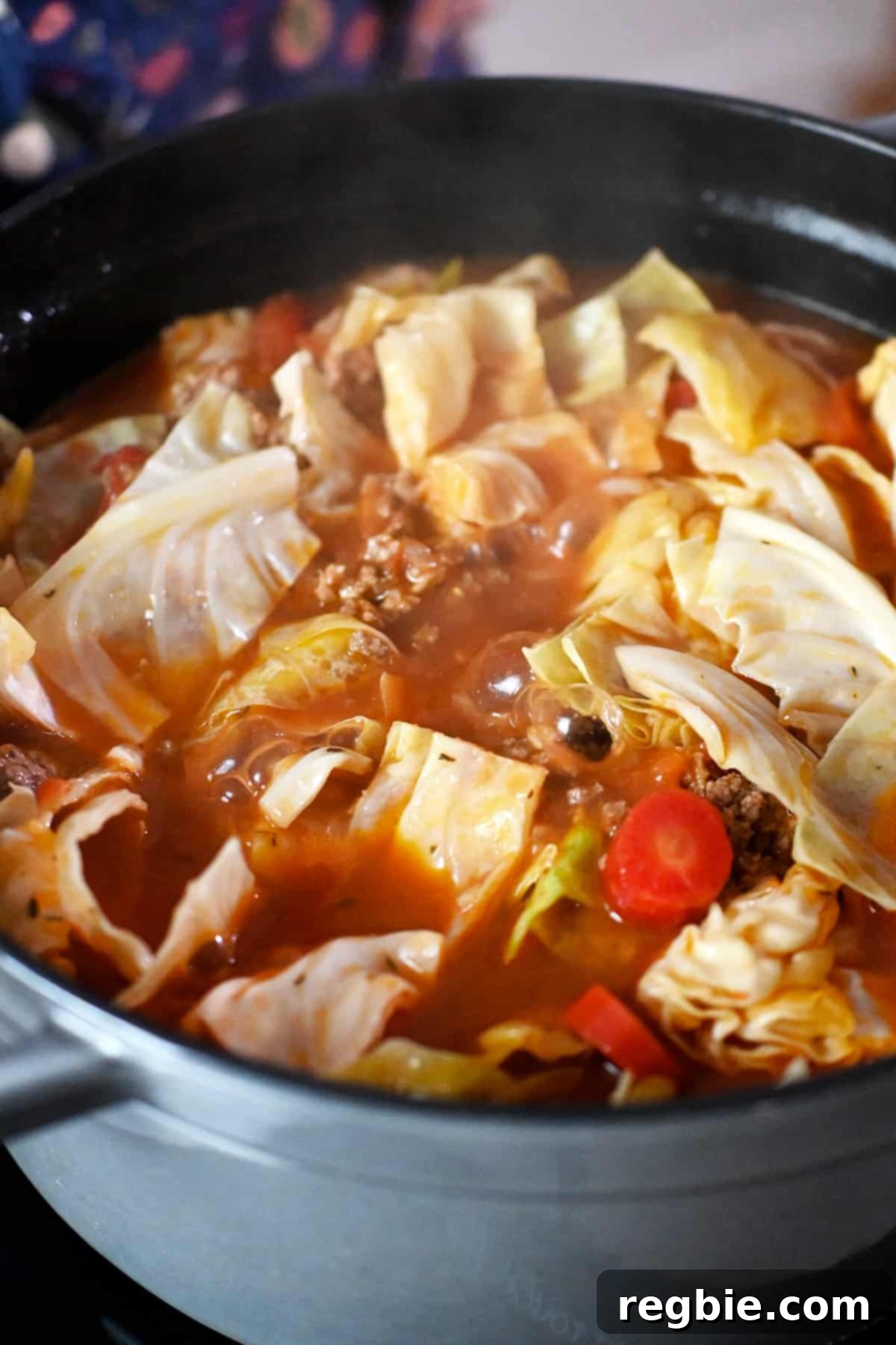 A close-up of a pot of cabbage roll soup simmering on a stove top.