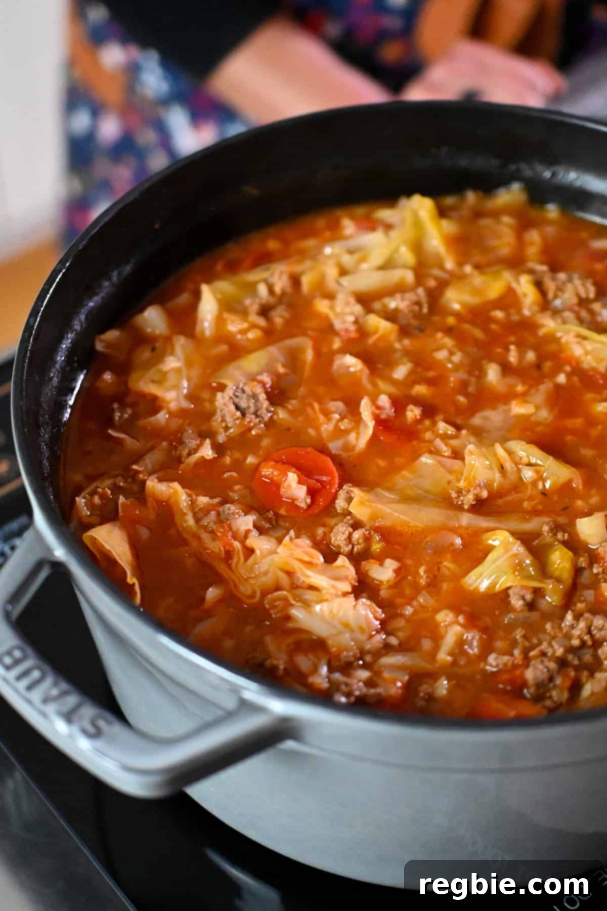 A side view of a gray pot filled with paleo and Whole30 unstuffed cabbage soup, or cabbage roll soup, ready to serve.