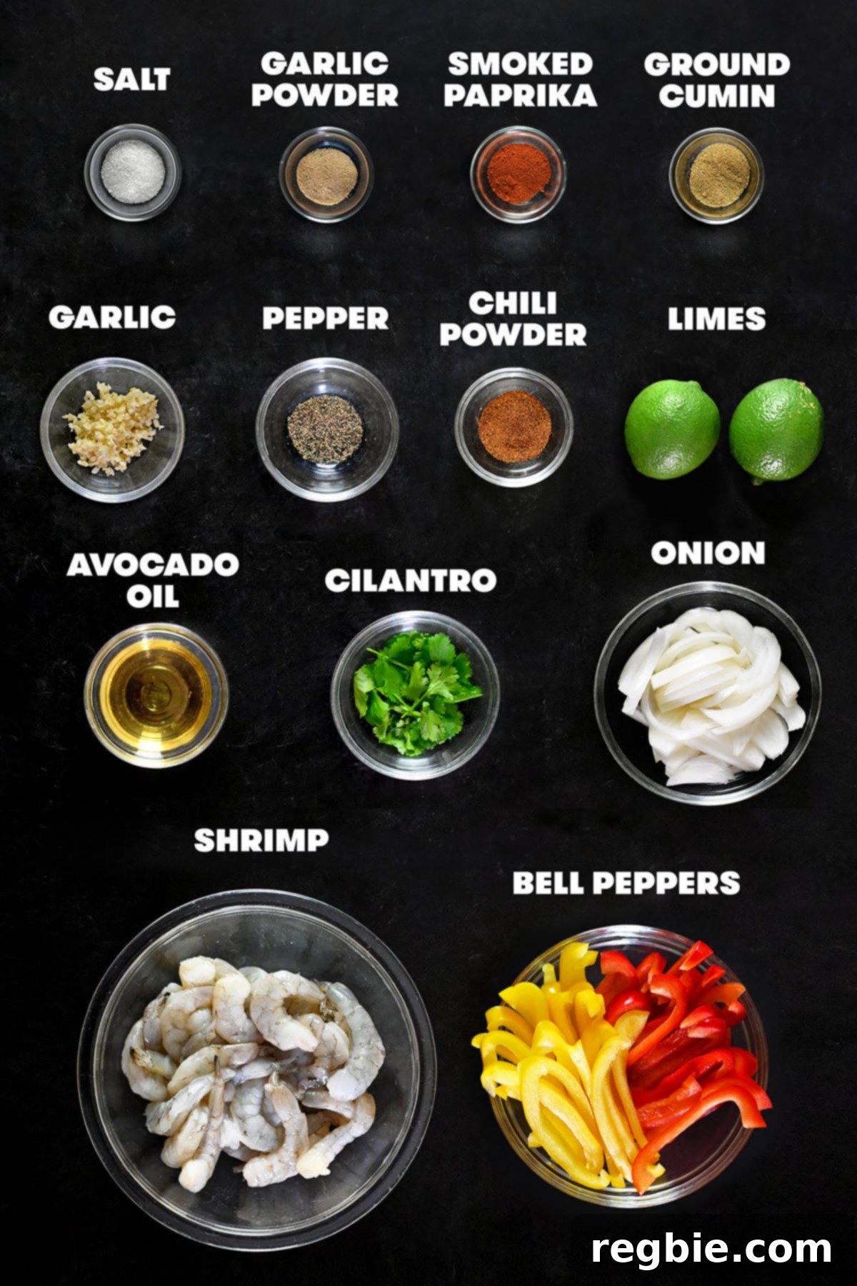 An overhead shot showcasing all the raw, fresh ingredients required to prepare delicious shrimp fajitas, neatly arranged.