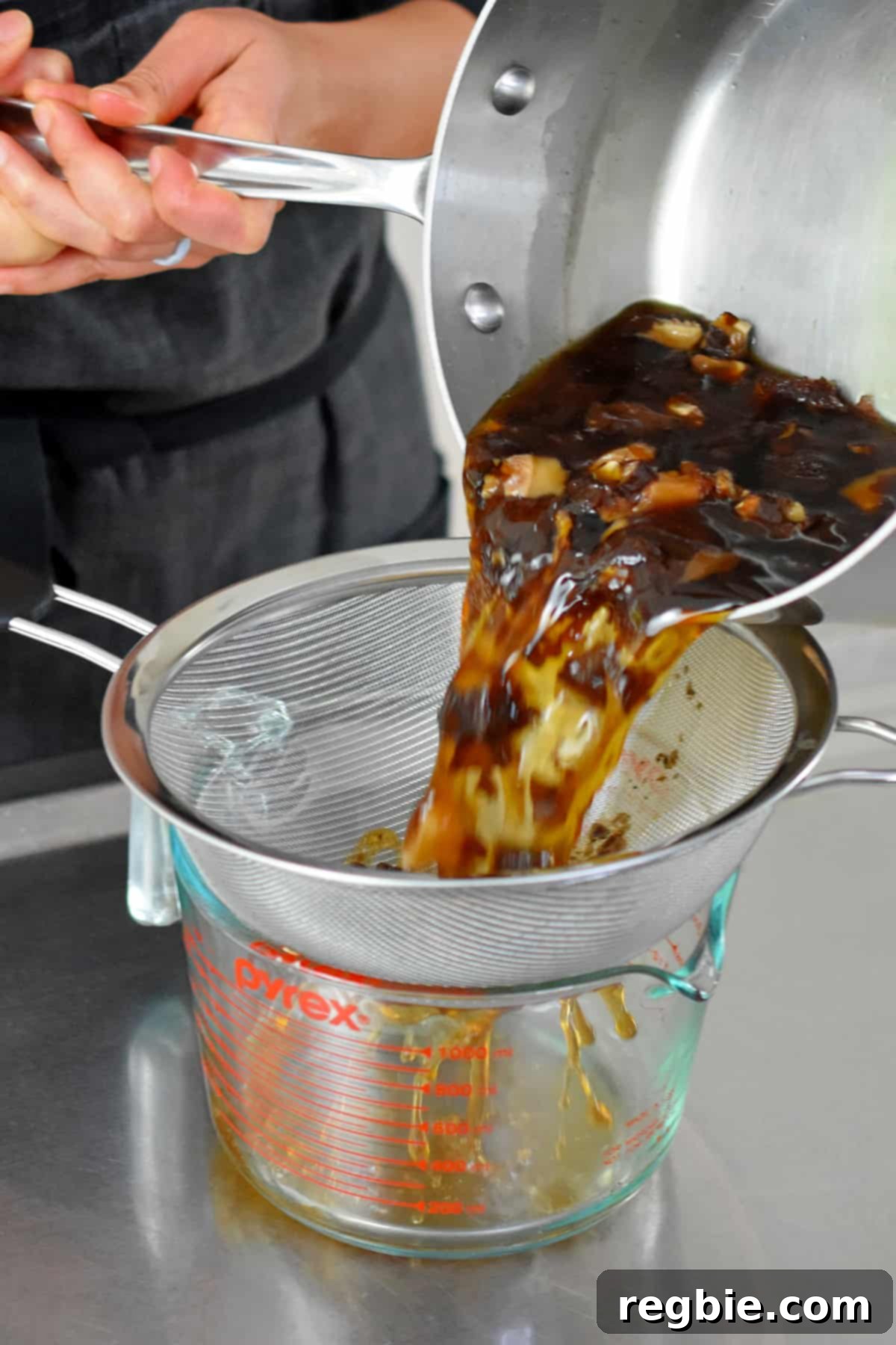 Oceanic Savory Drip 8 Straining vegan fish sauce through a fine mesh sieve to collect the shiitake mushrooms and dulse.