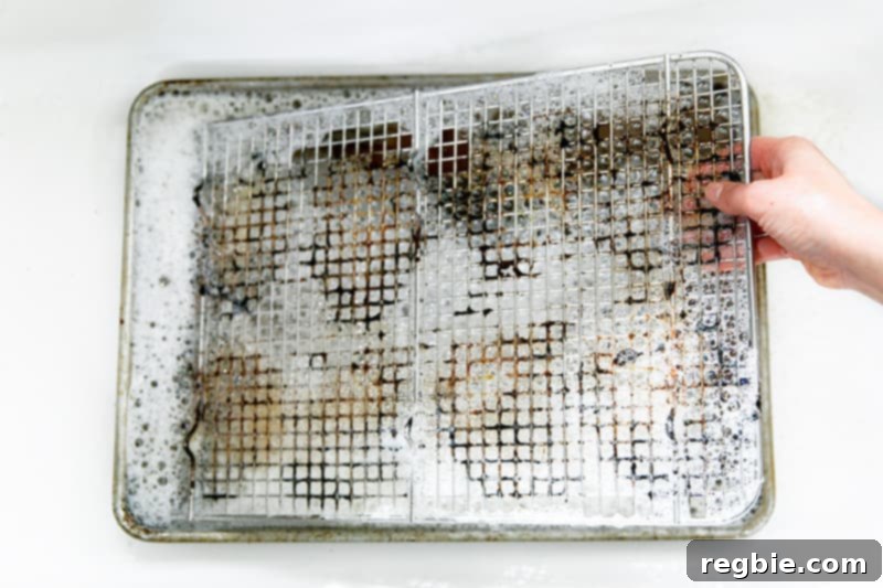Soaking a dirty wire rack in hot soapy water to clean it.