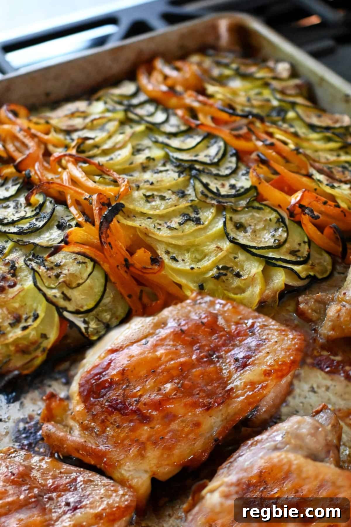 A close up of the cooked sheet pan ratatouille chicken and veggies right out of the oven.