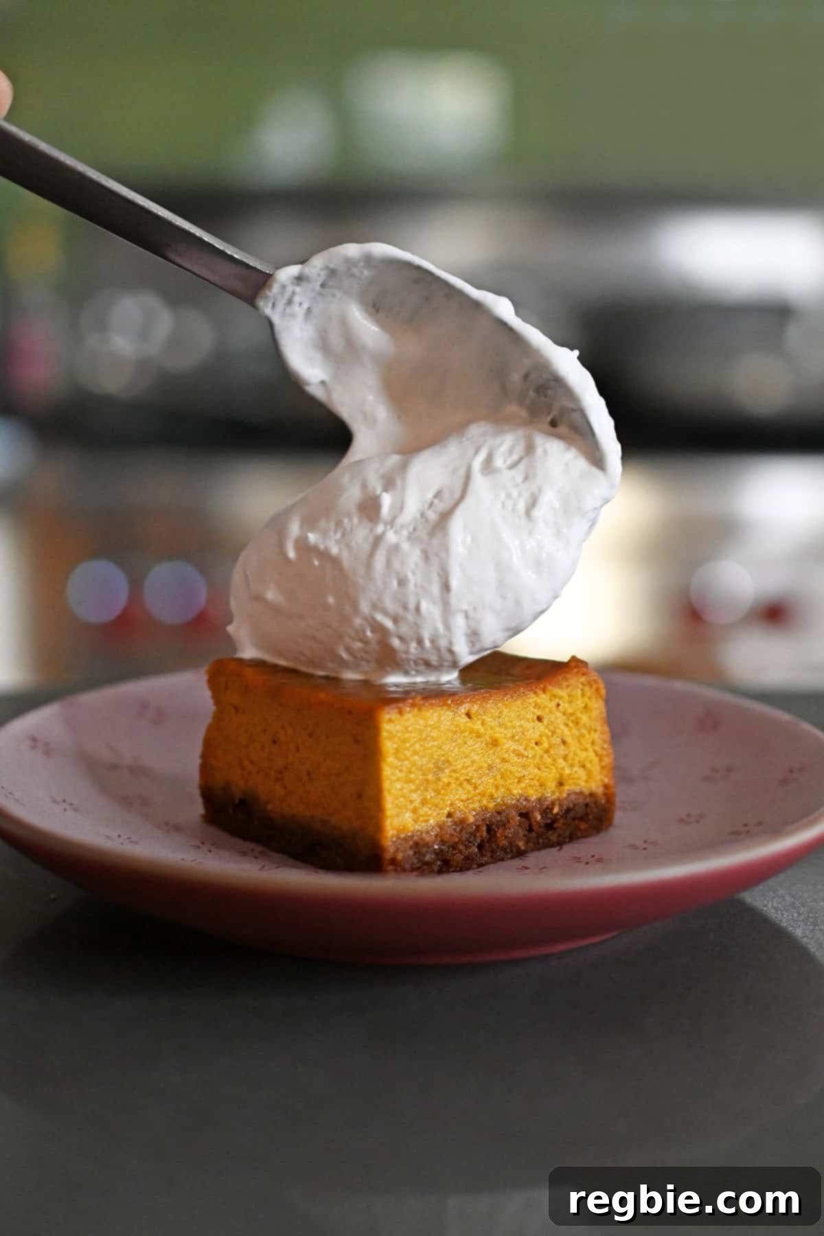 Golden Harvest Pumpkin Bars 3 Topping a square of pumpkin pie bars with a dollop of whipped coconut cream.