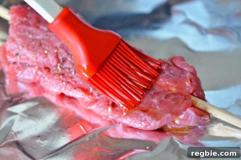 Melted ghee is brushed on top of the Whole30-friendly beef kabobs before hitting the grill.