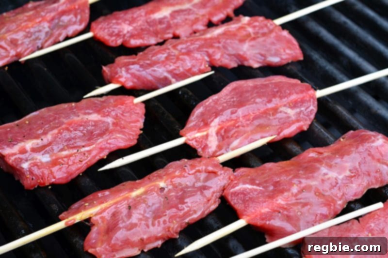 A shot of the Smashed Steak Skewers on a hot grill.