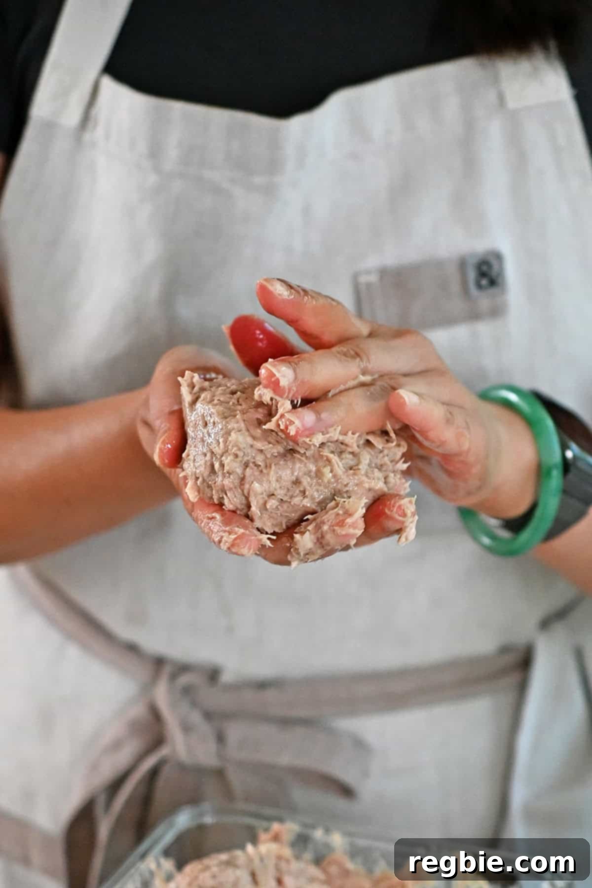 Forming raw turkey burger patties by hand.