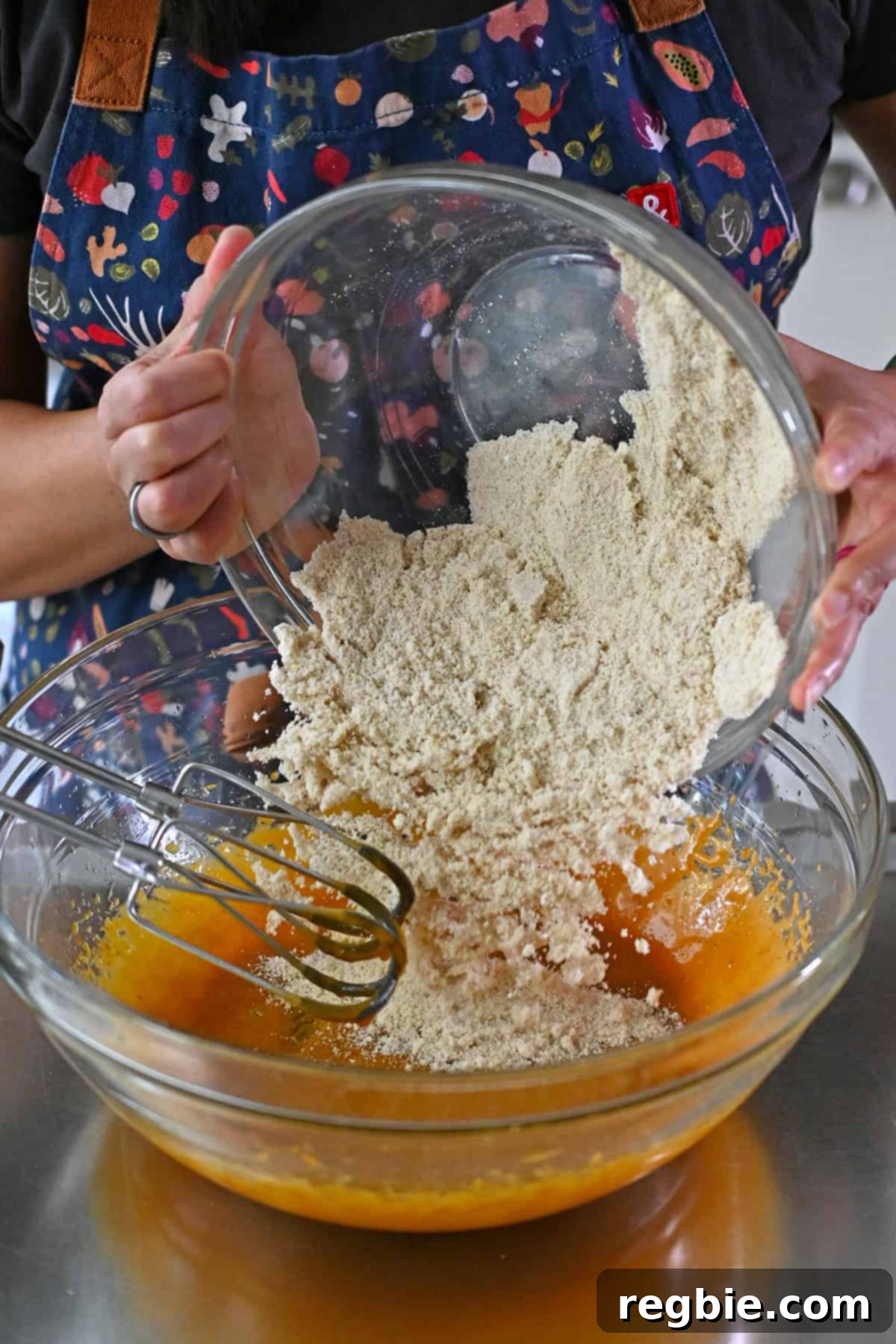 Adding the dry ingredients to the bowl of wet ingredients to make pumpkin snickerdoodle cookies.