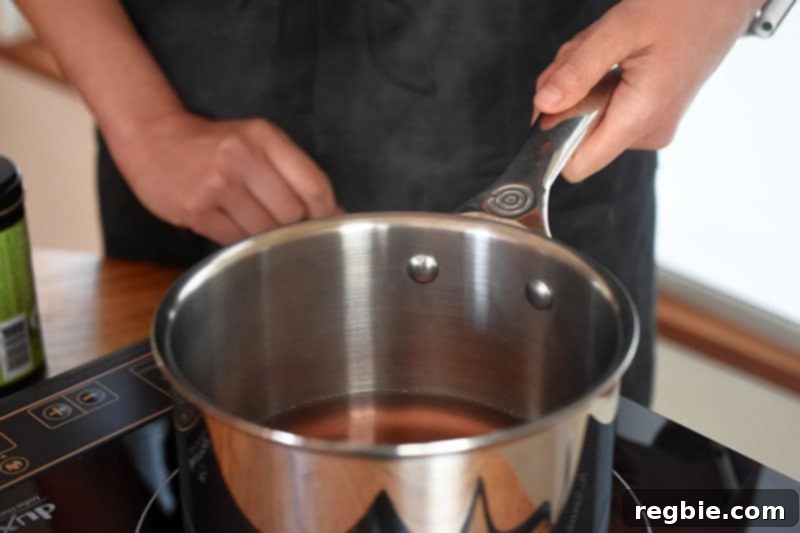 Coconut water steaming gently in a saucepan, indicating it has reached the ideal temperature.