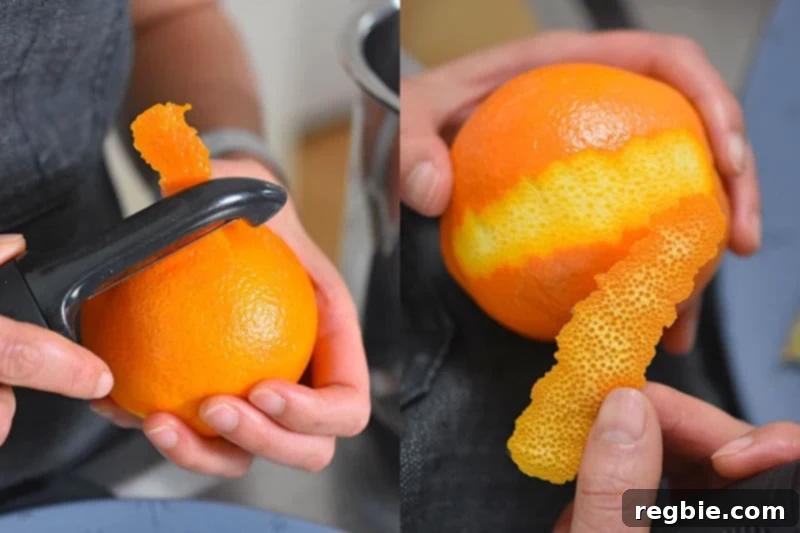 A black vegetable peeler carefully removing wide strips of zest from an orange, avoiding the bitter white pith beneath.
