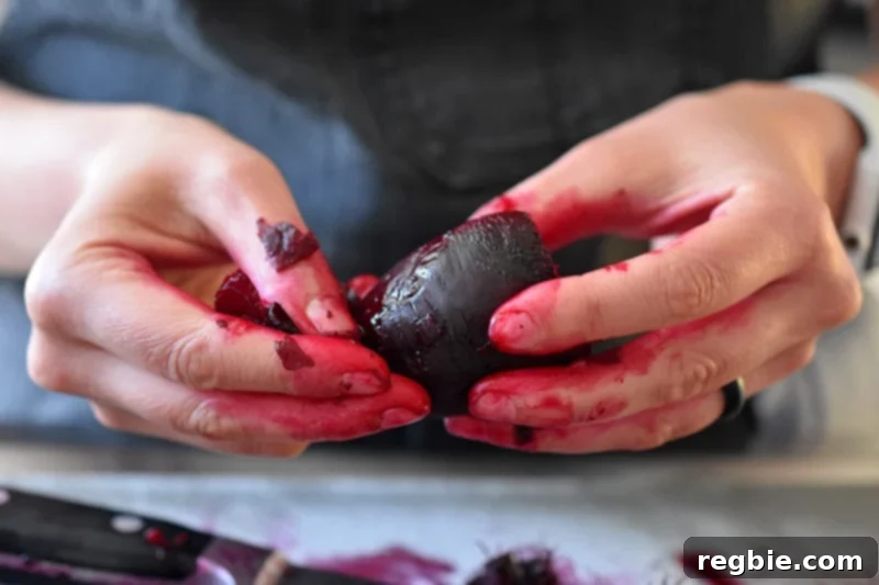 Perfect Instant Pot Beets 12 Someone peeling the skin of a cooked beet.