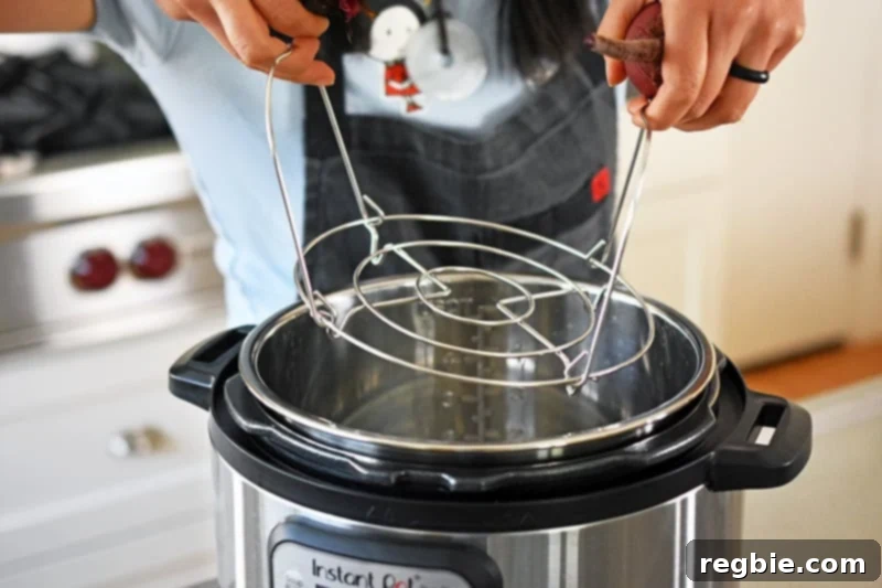 Perfect Instant Pot Beets 6 Someone inserting a metal rack into an instant pot.