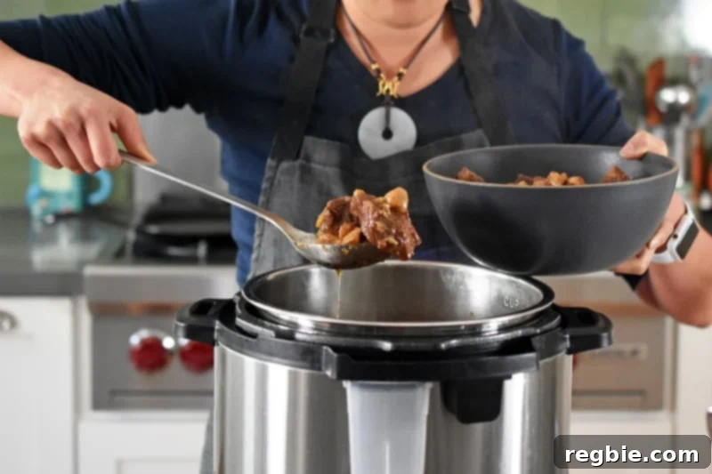 Spooning Instant Pot Beef Stew into a serving bowl