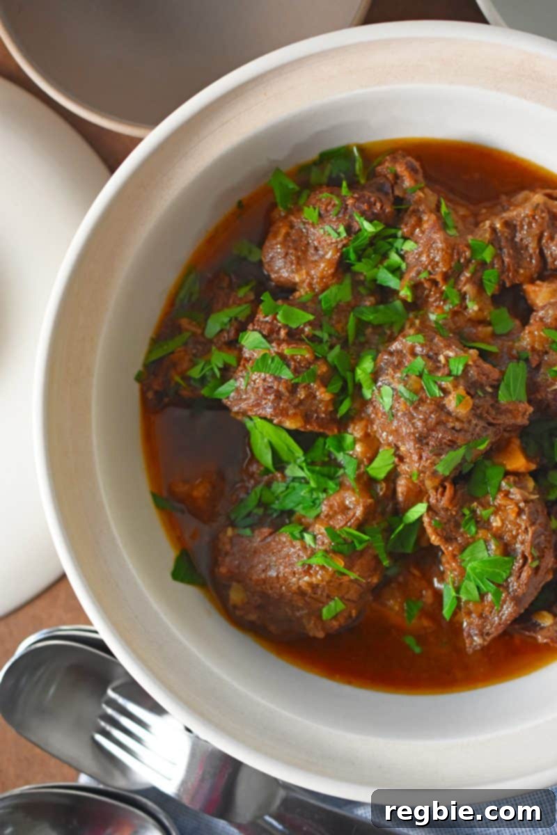 An overhead shot of Instant Pot Beef Stew in a cream colored serving bowl