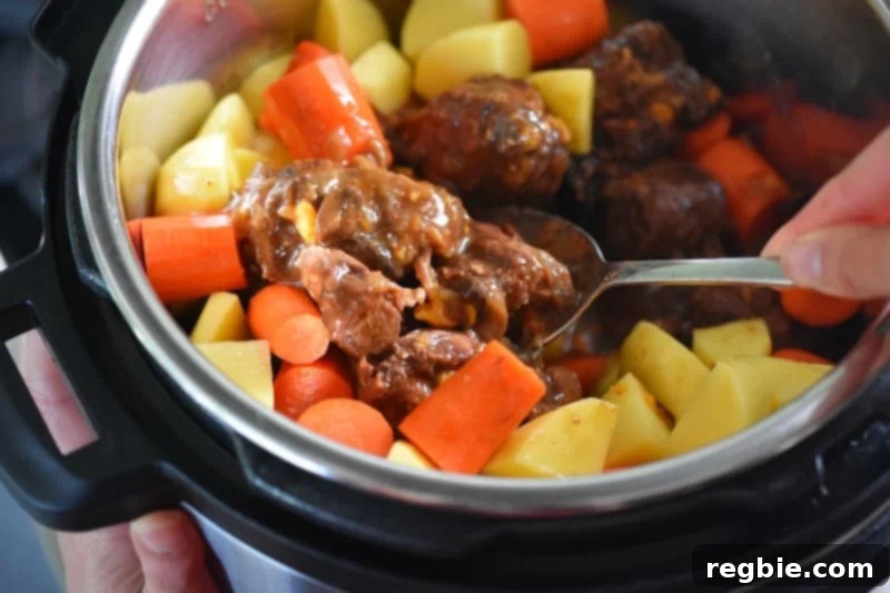 Stirring the Instant Pot Beef Stew to distribute the root vegetables
