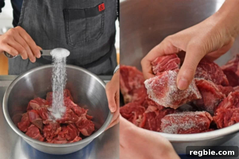 Salting the beef cubes in a silver bowl.