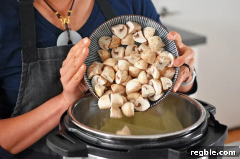 Adding quartered button mushrooms to an open Instant Pot