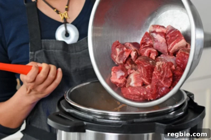 Adding the salted beef cubes to the Instant Pot