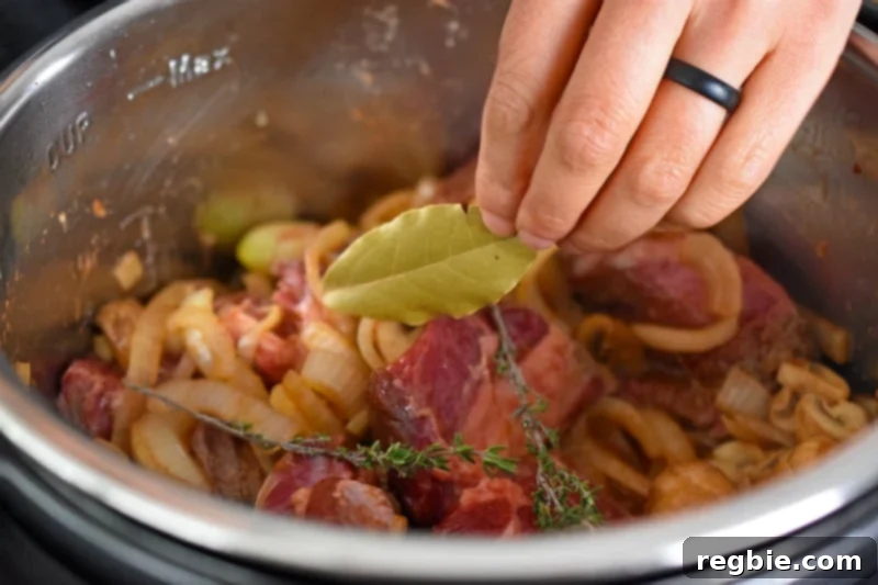 Adding a dried bay leaf and thyme sprigs to Instant Pot Beef Stew 