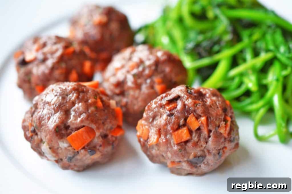 Sticky Glazed Asian Meatballs 12 A beautifully plated serving of Asian Meatballs accompanied by vibrant, sautéed green vegetables, illustrating a perfect, healthy meal prep option.