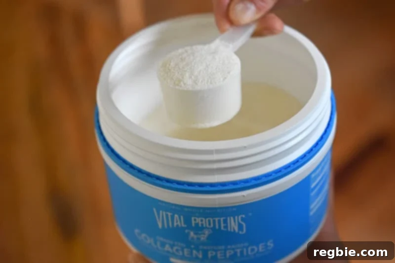 Refreshingly Cool Whole30 Dairy-Free Iced Matcha Latte 4 Someone using a scoop to measure unflavored collagen peptides powder from a container.