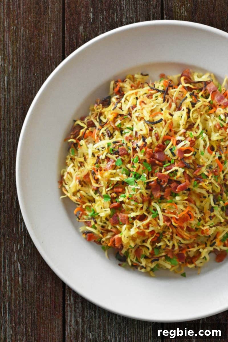 An overhead shot of a plate of Crispy Swoodles with Bacon, a Whole30 and paleo side dish made with spiraled sweet potatoes