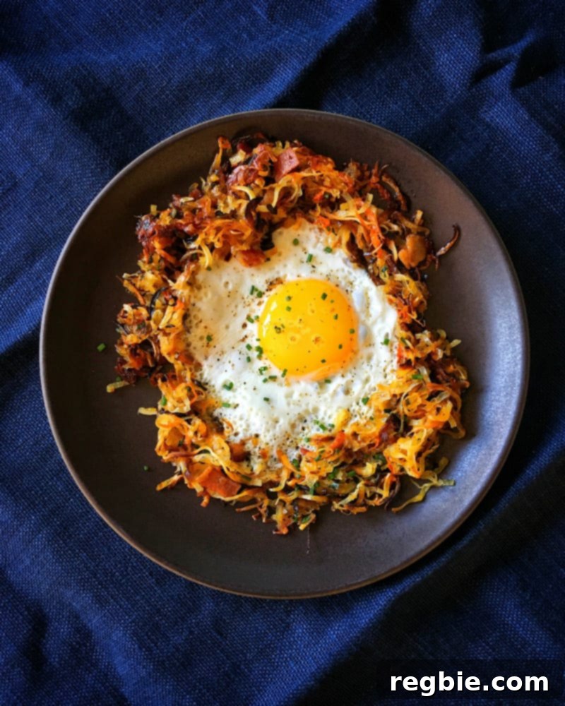 An overhead shot of a fried egg in a Crispy Swoodles with Bacon nest!