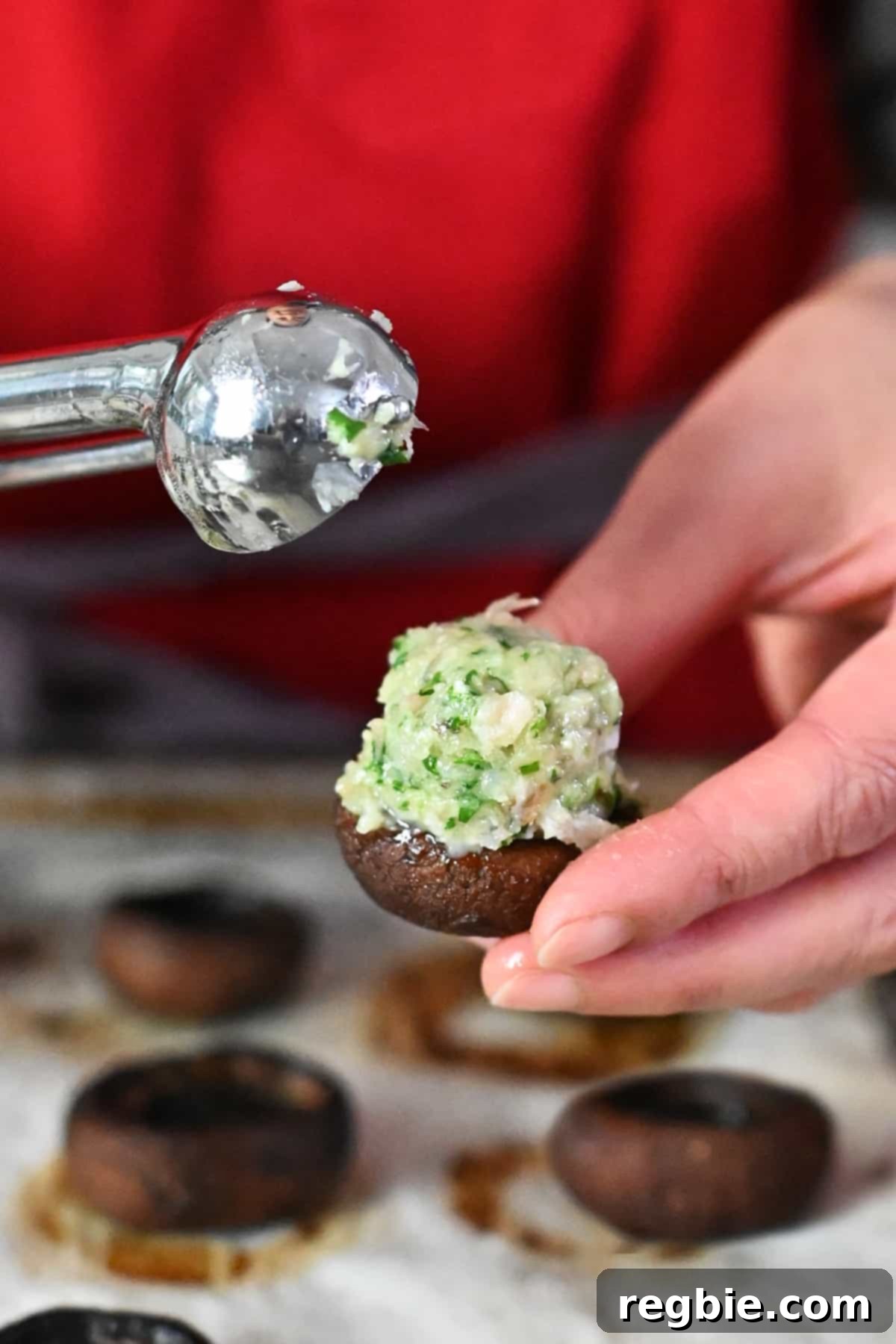 A detailed close-up of beautifully prepared shrimp-stuffed mushrooms, neatly arranged on a baking sheet and ready to be transferred to the oven for baking.