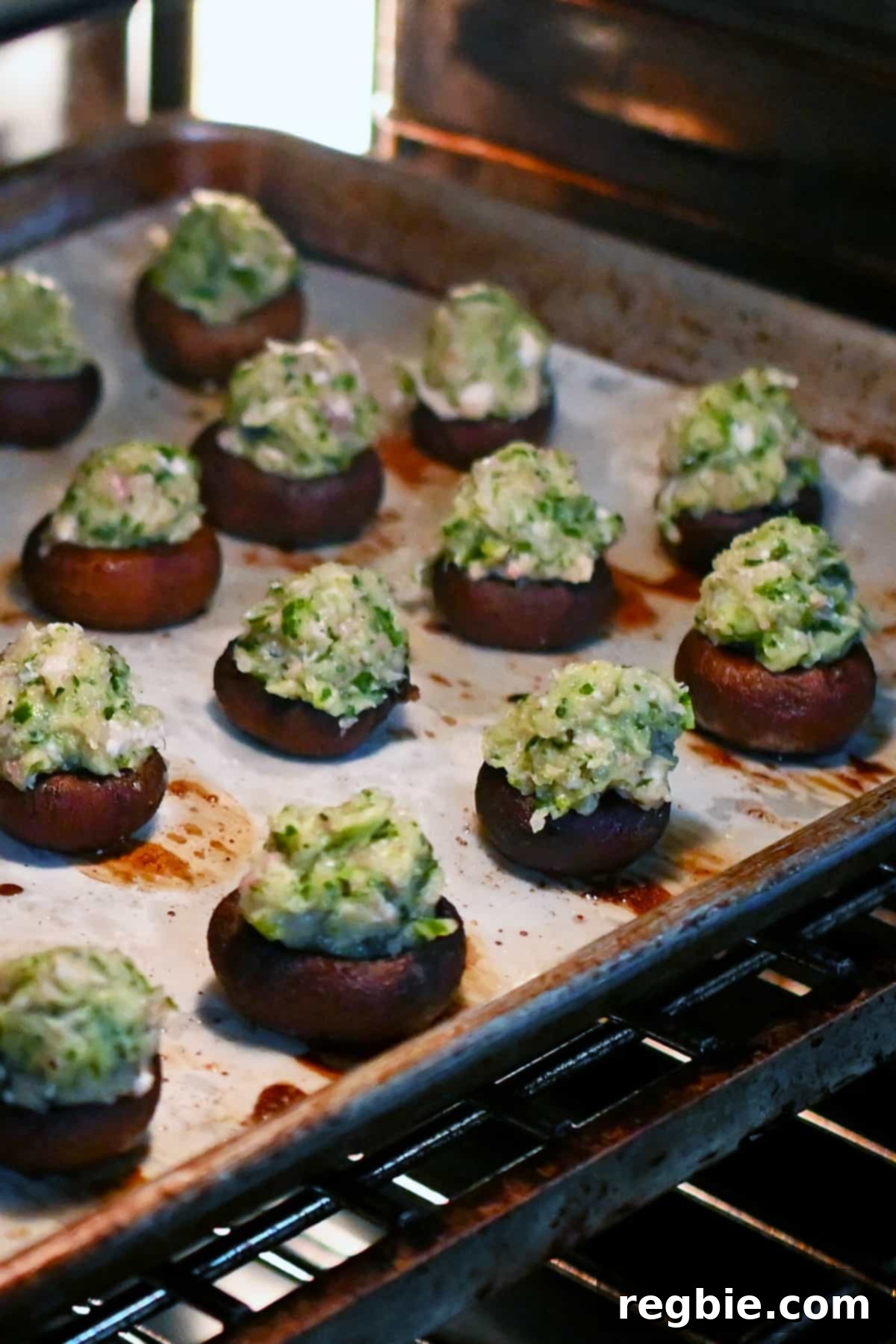 A baking tray laden with perfectly assembled shrimp stuffed mushrooms, entering the warm embrace of the oven for their final bake.