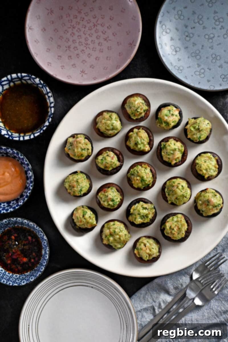 An inviting overhead shot of a platter of golden-brown shrimp stuffed mushrooms, perfectly arranged next to an assortment of savory dipping sauces, ready to be enjoyed.