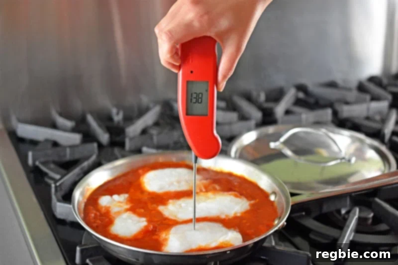 Quick Tomato Poached Cod One-Pan Meal 12 A Thermapen Mk4 instant-read thermometer is accurately inserted into the thickest part of a cod fillet, with its digital display clearly showing an internal temperature of 138°F, indicating that the fish is cooked to perfect doneness.