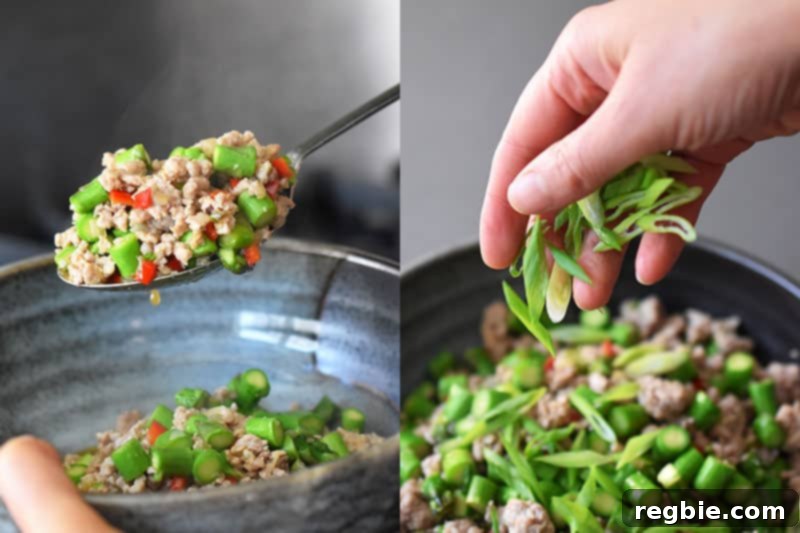 Transferring the Spicy Pork and Asparagus Stir-Fry to a serving bowl and topping it with sliced scallions.