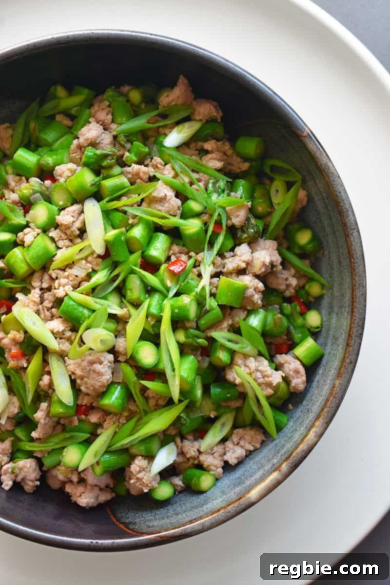 An overhead closeup shot of Spicy Pork and Asparagus Stir-Fry in a serving bowl, a Whole30 and keto weeknight dinner!