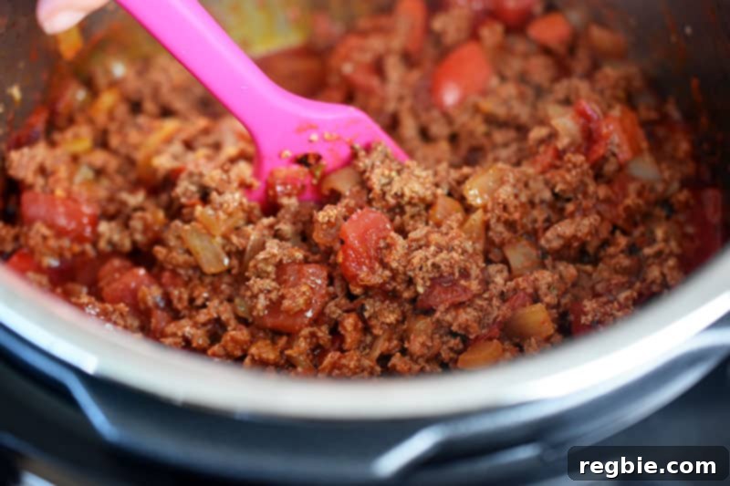 An image of Instant Pot Ground Beef Chili right before it is cooked under pressure. The meat is browned and the vegetables are tender.